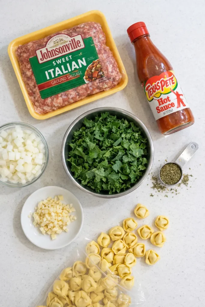 Creamy Sausage Tortellini Soup in a white bowl with kale, cheese tortellini, and sausage in a light cream broth